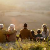 Back-view-of-extended-family-relaxing-in-autumn-day-on-a-hill-resized