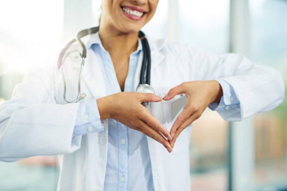 Portrait of a young female doctor making a heart shape with her hands
